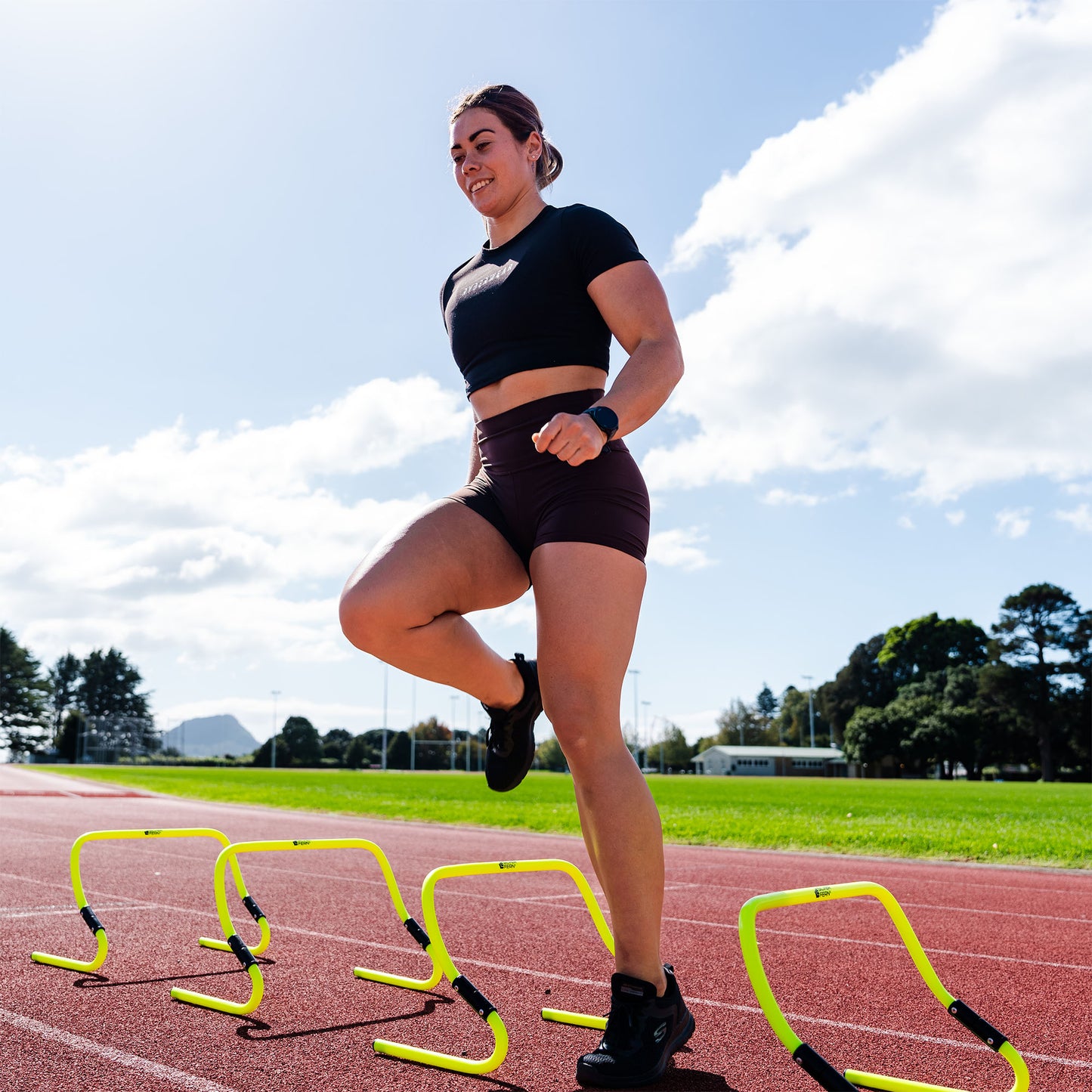 A lifestyle shot of a Set of Adjustable Agility Hurdles being used by an Athlete.