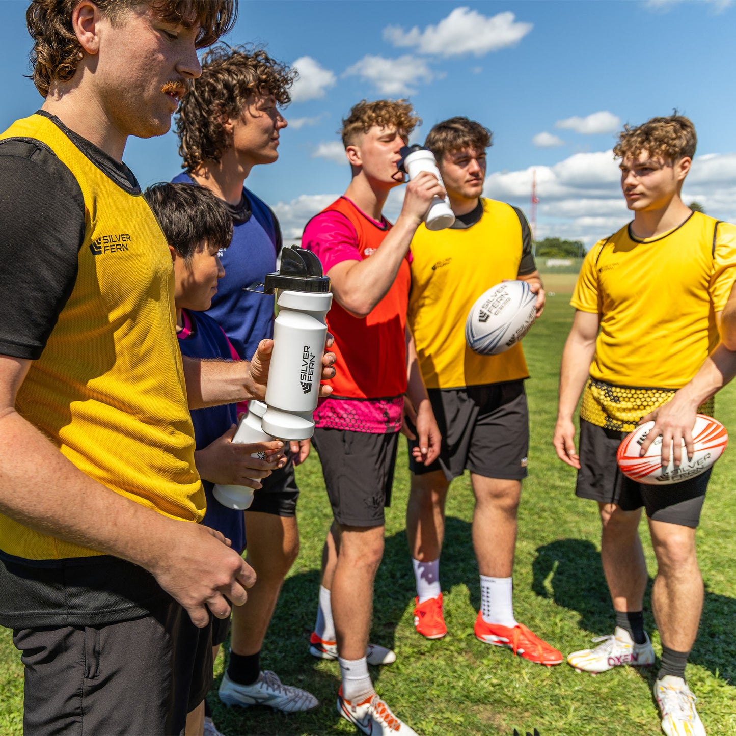 Hygiene drink bottle, lifestyle shot, group of rugby players having a break and drinking water out of the hygiene cap with chin rest 